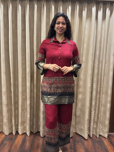 Deep maroon with black flowy blended silk fabric shirt style collar embroided detailing,highlighted with ethnic woven borders  with matching art work pant