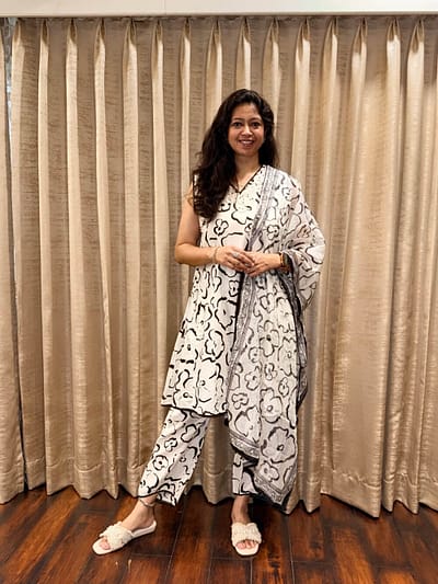 White base with bold black  A-line kurta with bold black hand-drawn floral motifs  Soft organza matching print dupatta