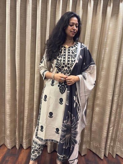 Elegant ivory white base with striking black embroidery on full suit extended to sleeves